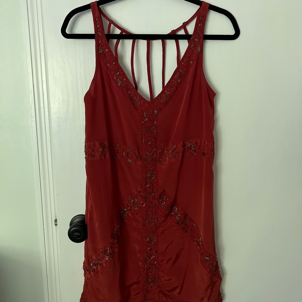 Burnt orange dress with bronze beaded detail. Open back with strappy pattern